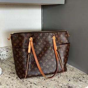 Louis Vuitton tote bag with side pockets and zipper